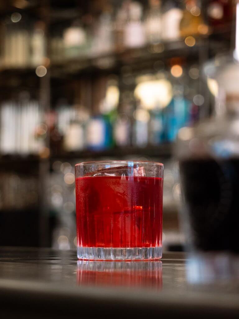 Picture of a Beetroot Negroni in a small rocks glass.